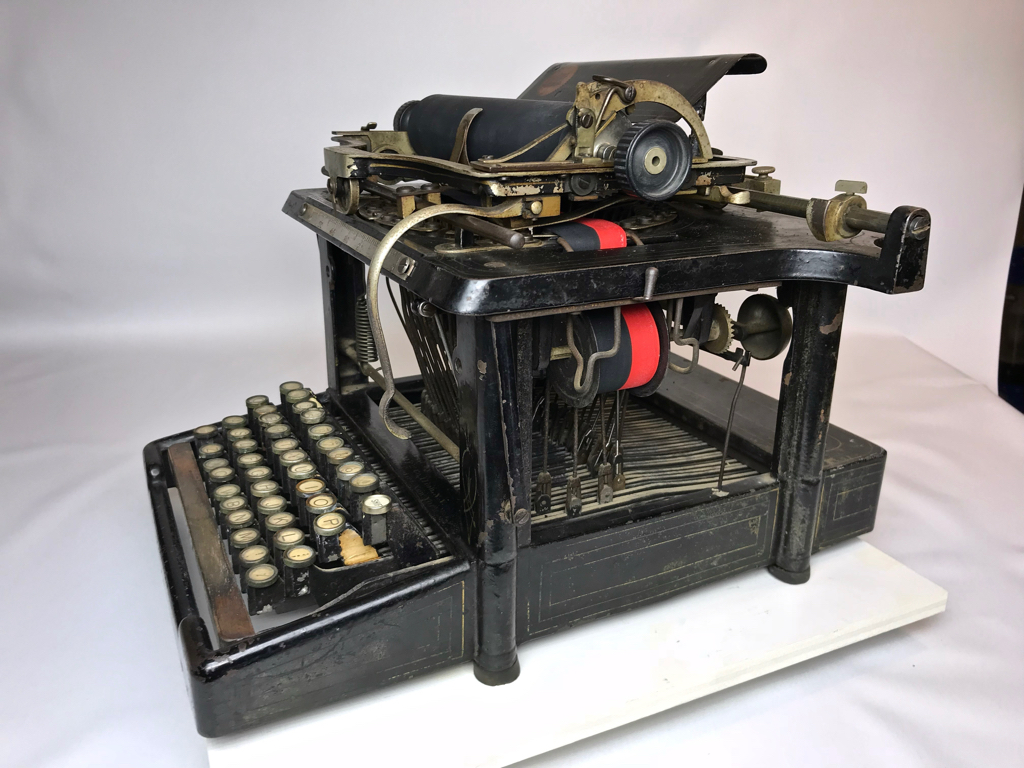 This is an upstrike machine. The keys strike the paper on the bottom of the platen. The typist had to rotate the carriage to see what had been typed.